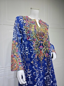 Detailed close-up of colorful embroidery and sequins on navy mesh maxi dress neckline