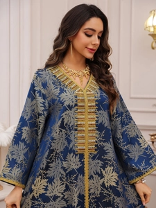 Detail of navy blue kaftan dress with golden leaf print and intricate beadwork embroidery