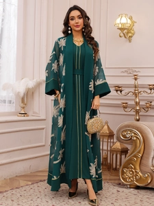 Detail of dark green embroidered abaya with sheer fabric and gold leaf patterns