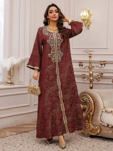 Detail of red jacquard kaftan featuring golden embroidery and elegant beadwork detail