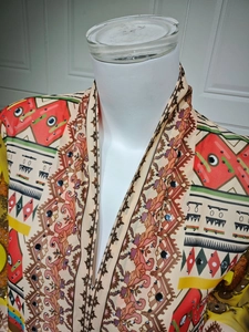 Detail of V-neck collar with ethnic print, sequins and bohemian patterns on chiffon dress
