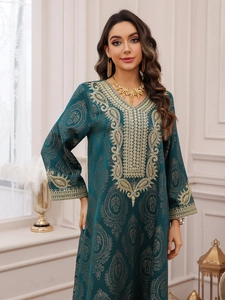 Détail d'une robe Caftan vert émeraude avec broderies dorées complexes et motifs cachemire