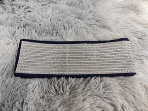 Détail d'un accessoire de robe bleu marine avec broderie chevron argentée et texture chic