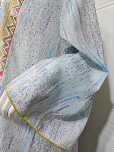 Détail d'une robe fleurie avec paillettes argentées et broderies géométriques