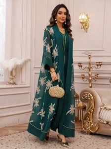 Detail of dark green embroidered palm tree cardigan with gold-edged chic jumpsuit