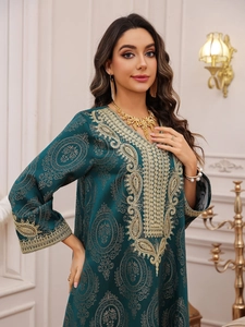 Détails de la robe caftan vert foncé avec broderies paisley dorées et texture en soie
