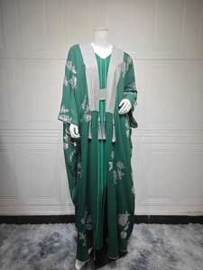 Détails de broderie et glands argentés sur une robe longue ethnique de couleur vert foncé