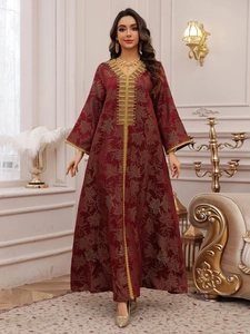 Close-up of deep red kaftan dress featuring gold embroidery and maple leaf jacquard texture