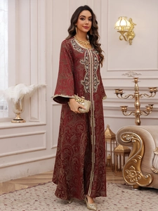 Close-up of deep red Kaftan with intricate gold embroidery and luxury beadwork detail
