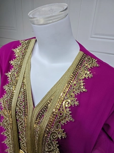 Detailed view of intricate gold embroidery and sequins on the neckline of a magenta dress