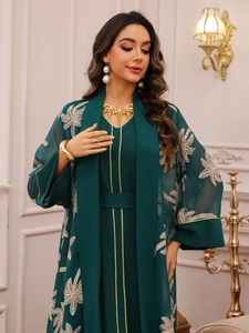 Detailed view of floral embroidery on a dark green tulle abaya and two-piece dress set