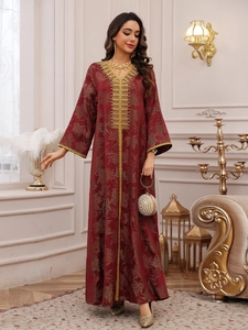 Detail of burgundy kaftan featuring gold leaf prints and intricate beadwork embroidery