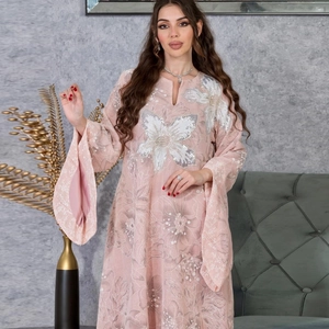 Detail view of pink kaftan with white floral prints and sequin flower embroidery on chest