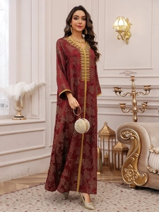 Detail of burgundy kaftan dress featuring gold leaf embroidery and sequins decoration