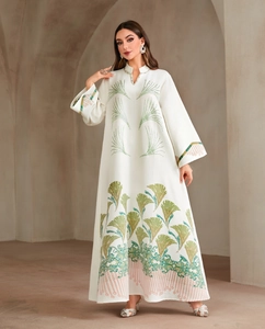 Detail of green and gold fan embroidery on white long-sleeved formal kaftan abaya