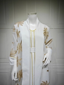 Detail of white abaya with gold leaf embroidery and metallic piping on sleeves and neck
