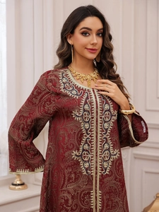 Detail of burgundy Kaftan evening dress with gold paisley embroidery and bell sleeves