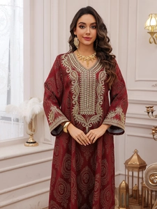 Détails de broderies dorées sur le col et les poignets d'une robe caftan bordeaux de luxe