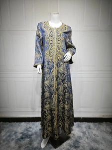 Detail of navy kaftan featuring intricate gold paisley jacquard and embroidered trims