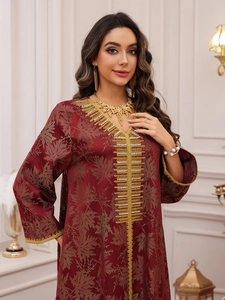 Close-up of golden embroidery and sequins on a dark red jacquard dress for women