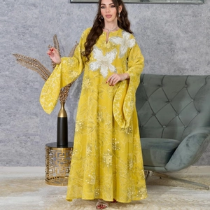 Detail of yellow maxi dress featuring silver sequin flower embroidery and flared sleeves
