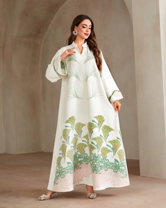 Close-up of white pleated abaya featuring green and pink floral embroidery with beadwork