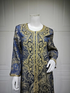 Macro shot of gold embroidery and intricate beadwork on navy blue brocade Kaftan dress
