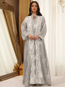 Detail der silbernen Netzstickerei und weißen Blatt-Applikationen auf einer grauen Abaya
