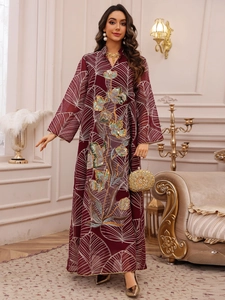 Vista dettagliata del ricamo floreale con paillettes su un abito lungo in tulle bordeaux