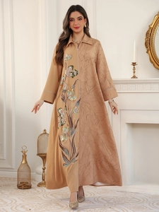 Detail of sequin floral embroidery and textured patchwork on a khaki ethnic maxi dress