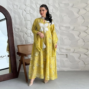 Macro shot of 3D floral lace applique and floral embroidery on a yellow abaya dress
