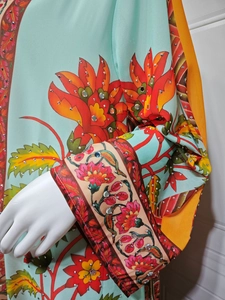 Détail d'une robe en mousseline fleurie montrant le tissu bleu menthe et les strass
