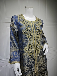 Detail of golden Baroque embroidery and beaded patterns on navy blue kaftan fabric