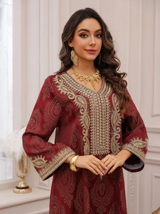 Détail de la robe caftan bordeaux avec motifs cachemire dorés et broderies de luxe