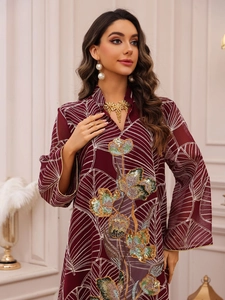 Dettaglio del ricamo floreale in paillettes su questo abito lungo in rete bordeaux