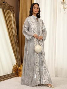 Nahaufnahme der silbergrauen Abaya mit Stickerei und Handtasche mit Perlengriff