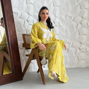 Close-up of yellow kaftan dress with white floral embroidery and v-neck detail