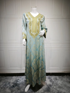 Détail du caftan bleu clair avec motifs damassés dorés et broderies luxueuses