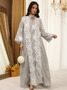 Nahaufnahme der Silberstickerei auf einem luxuriösen Netzkleid mit Trompetenärmeln