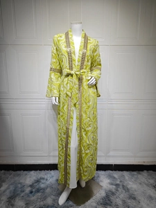 Dettaglio del kaftano floreale verde neon con paillettes dorate e maniche a campana
