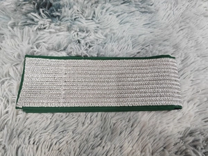 Détail de dentelle brodée verte avec motifs de vagues argentées pour robes élégantes