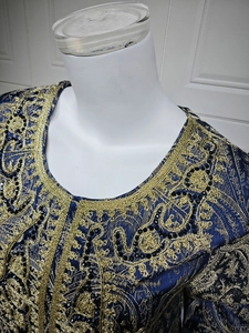 Detailed view of intricate gold embroidery and black sequins on dark blue Kaftan dress