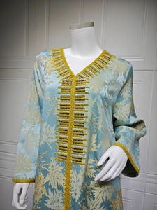 Detail of light blue robe dress featuring gold embroidery and maple leaf texture