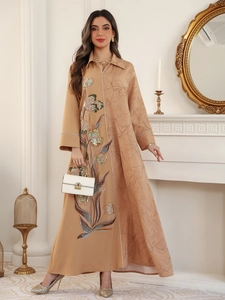 Detail of floral embroidery and sequins on elegant camel-colored ethnic dress fabric