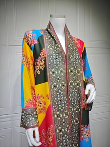 Detail of colorful floral print dress with intricate geometric patterns and crystal rhinestones