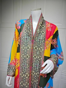 Detail of colorful kaftan dress showing floral patterns and sequin neckline