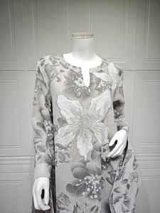 Detailed close-up of white sequin floral embroidery on long sleeve grey floral dress