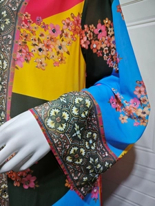 Detail of bohemian printed maxi dress showing floral patterns and silver rhinestone accents