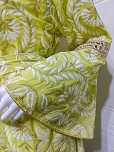 Dettagli di ricami dorati complessi e paillettes sulle maniche dell'abito lungo verde lime