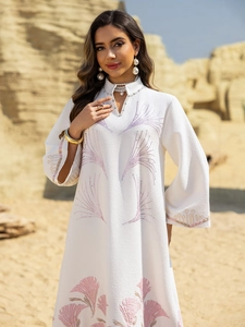 Detail of white long sleeve dress with purple floral embroidery and rhinestones